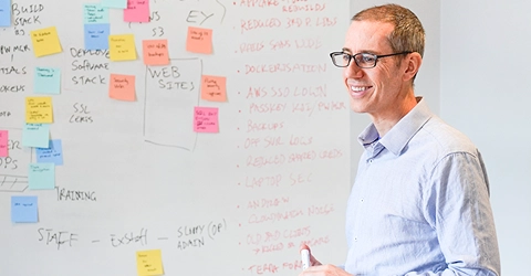 Brendan standing at a whiteboard during an investment day